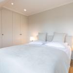Schlafzimmer mit Doppelbett, Nachttischen und Kleiderschrank unter Dachschrägen.