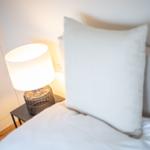Bettkopfteil mit Kissen und Nachttisch mit Lampe
