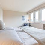 Schlafzimmer mit Bett, Fenster und Sitzgelegenheit