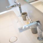Hochwertige Waschbecken mit modernen Wasserhähnen und Pflegeprodukten.
