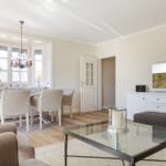 Living and dining area with TV, table and chairs, and glass-top table.