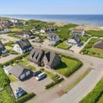 Dorf mit Häusern und Strand im Hintergrund