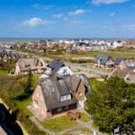 Village with thatched houses and view of the sea