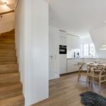 Entrance with stairs, kitchen, and dining table with chairs.