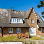 House with red brick, black roof, and white door