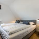 Bedroom with double bed, window, and nightstand.