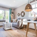 Living and dining area with sofa, table, and windows.