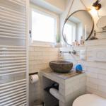 Bathroom with stone sink, mirror, and radiator.