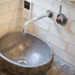 Stone sink with faucet and wall-mounted control