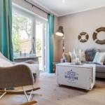 Living room with armchair, sofa, and maritime decorations.