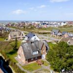 Village with thatched houses and view of the sea.