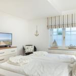 Bedroom with double bed, TV, and window with view.