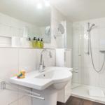 Bathroom with shower, sink, and mirror
