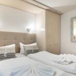 Bedroom with double bed, wardrobe, and mirror on the wall.