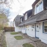 White houses with thatched roofs and stone garden path