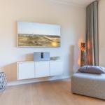 Living room with wall art, cabinet, and ottoman. Access to terrace.