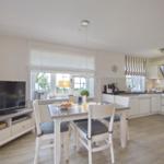 Kitchen and dining area with dining table, chairs, and TV