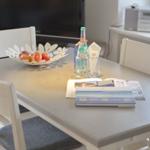 Dining table with chairs, fruit bowl, and water bottles.