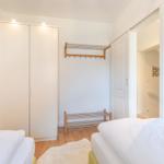 Zwei Betten, Kleidergarderobe und Hängeregler im Schlafzimmer.