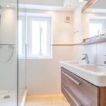 Badezimmer mit Dusche, Waschbecken und Fenster