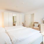 Schlafzimmer mit Doppelbett, Kleiderschrank und Fernseher