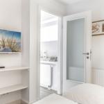 Bedroom with bed, TV, and door to bathroom.