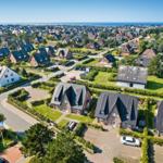 Aerial view of houses with green gardens and sea view