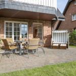 Terrasse mit Sitzgruppe und Strandkorb vor Backsteinhaus