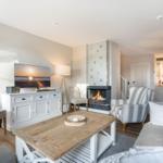 Wohnzimmer mit Kamin, Sofa, Fernseher und Essbereich