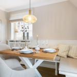Dining table with bench, window, and ceiling light.