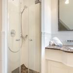 Shower with glass enclosure and sink with mirror