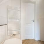 Bathroom with shower, toilet, and wall-mounted heater.