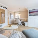 Living and dining area with modern furniture and large window.