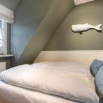 Bedroom with sloped ceiling, bed, and wall decoration.