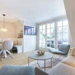 Living and dining area with TV, windows, and modern furniture.