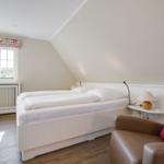 Schlafzimmer mit Doppelbett, Fenster und Sessel