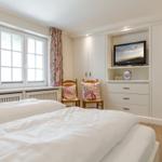 Schlafzimmer mit Doppelbett, Fenster, TV und Schrank