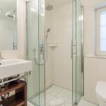 Badezimmer mit Dusche, Waschbecken und Toilette.