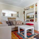 Wohnzimmer mit Sofa, Couchtisch und Fernseher an Wandregal