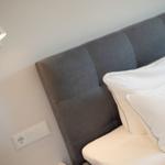 Bed headboard with pillows and wall lamp