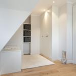 Bedroom with wardrobe, shelves, and wooden floor.