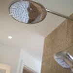 Showerhead on ceiling and handheld shower on wall