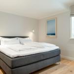 A bedroom with a bed, a window, and wall decor.