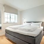 Bedroom with double bed, window, and mirror