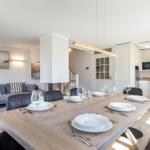Dining area with table, chairs, and view into kitchen and living room.