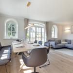 Dining area with table and chairs, living area with sofa and fireplace