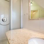 Bathroom with shower, sink, and mirror