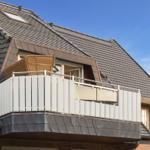 Attic balcony with white railing and wicker furniture