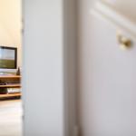 TV on wooden stand in bedroom with light walls