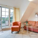 Living room with sofa, armchair, and terrace door